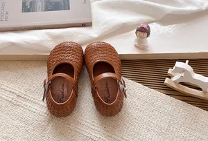 Vista de detalle superior de la textura tejida marrón de los zapatos Mary Jane niña