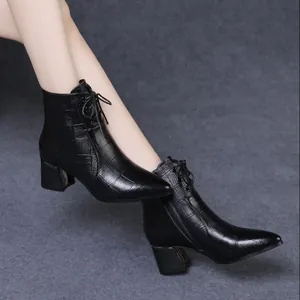 Schwarze spitze Stiefeletten mit Blockabsatz und Krokoprägung am Modell getragen