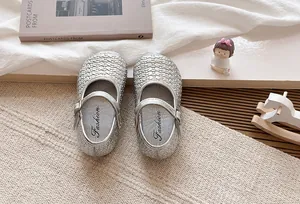 Detalle de manoletinas Mary Jane trenzadas plateadas para niña con estilo francés