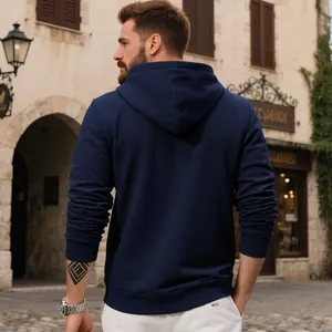 Vista trasera de una sudadera con capucha azul marino de alto gramaje en entorno urbano.