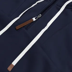 Primer plano de sudadera azul marino con cremallera plateada y detalle de cordón de ajuste.