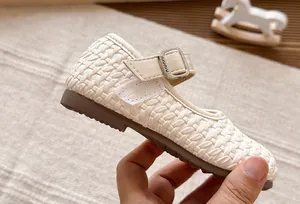 Detalle de las bailarinas Mary Jane trenzadas crema para niñas con correa de hebilla metal