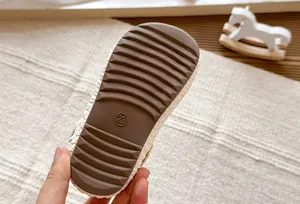 Detalle de la suela de goma con marca de talla 23 en zapatos planos para niñas