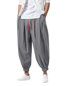Vista detallada de pantalones harem de lino y algodón gris con llamativos cordones rojos