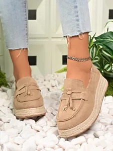 Detailed view of women's beige suede platform loafers with jute espadrille sole and tassel