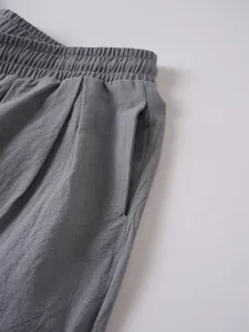 Detalle de primer plano de pantalones grises de lino y algodón con cintura elástica.