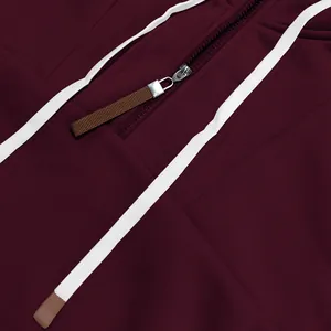 Primer plano de la cremallera plateada y el cordón blanco en sudadera granate de tejido polar