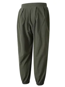Vista detallada de pantalones jogger de algodón y lino verde oscuro con cintura elástica