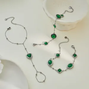 Dettaglio del set di bracciali vintage francesi con cuore verde smeraldo e pietre preziose