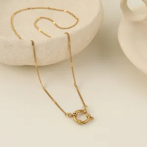 Dettaglio di una collana in acciaio inossidabile dorato con chiusura a molla tonda