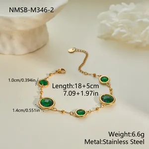 Detalle de primer plano de una pulsera de acero con circonitas verdes y medidas