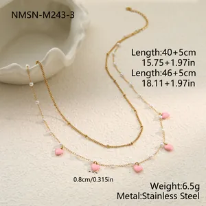 Detailansicht einer zweilagigen Edelstahlkette mit eleganten rosa Herzen und feinen Perlen.