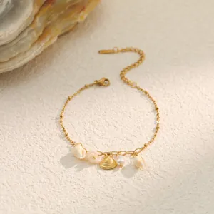 Detailed close-up of gold stainless steel bracelet with natural shells and pearl charms