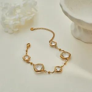 Elegant gold bracelet featuring faceted clear square crystals on a minimalist chain.