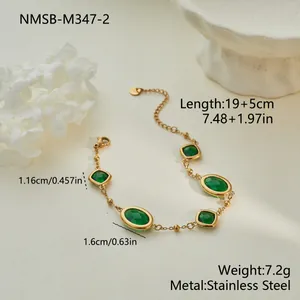 Vista detallada de una elegante pulsera de acero dorado con piedras de circón verde