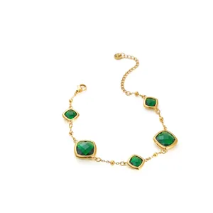 Vista detallada de pulsera de acero inoxidable dorado con circonitas verdes cuadradas