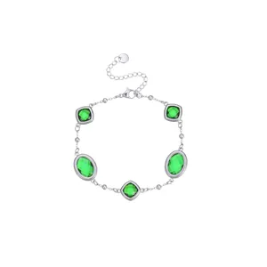 Vista dettagliata di un bracciale a catena in argento con pietre verdi sfaccettate di lusso
