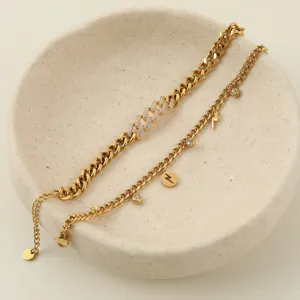 Détail de bracelets à maillons cubains dorés et breloques éclair dans un bol.