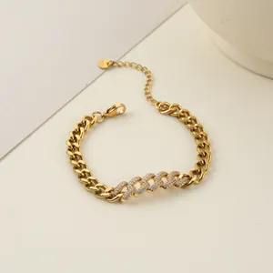 Gros plan d'un bracelet gourmette doré avec une section centrale sertie de cristaux.