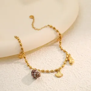 Close-up view of a gold stainless steel bracelet featuring natural and metallic shell charms