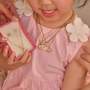 Lifestyle-detail van een schattige glanzende hartjesketting en oorbellen voor meisjes.