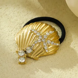 Detailed macro shot of a golden shell and rhinestone starfish stainless steel hair tie