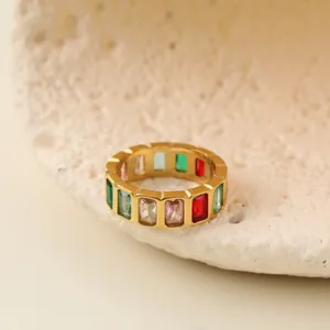 Macro view of a gold stainless steel ring featuring colorful geometric gemstones