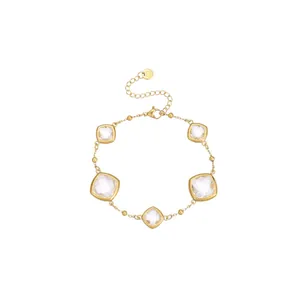 Detailed view of elegant gold bracelet featuring five clear square faceted crystals