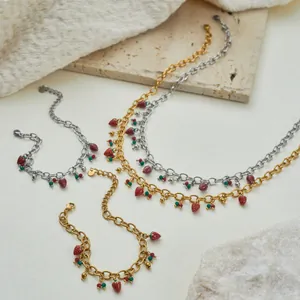 Detailansicht eines Erdbeerschmucksets aus Edelstahl mit Gold- und Silberketten.