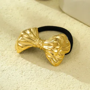Detailed macro view of a golden stainless steel bow-shaped hair tie with shell texture