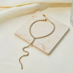 Close-up of a gold stainless steel Y-shaped slave bracelet set with sparkling crystals