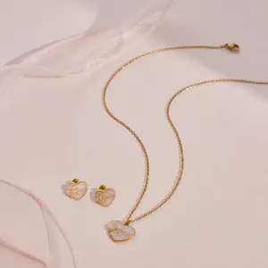 Detail van een schattige roestvrijstalen sieradenset met hart en strik in roze glitter emaille.