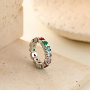 Close-up of a stainless steel ring with colorful heart-shaped gemstones on stone blocks