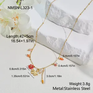 Detailed view of stainless steel necklace with ginkgo leaf and red flower beads