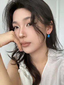 Mannequin portant des boucles d'oreilles gouttes d'eau bleues en acier titane