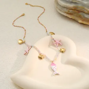 Macro detail of summer ocean-themed necklace featuring pink drip oil fish and starfish charms