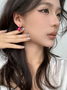 Gros plan boucle d'oreille goutte d'huile magenta portée par un magnifique mannequin asiatique