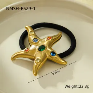 Detailed macro view of 18k gold plated starfish hair tie with colorful crystals.