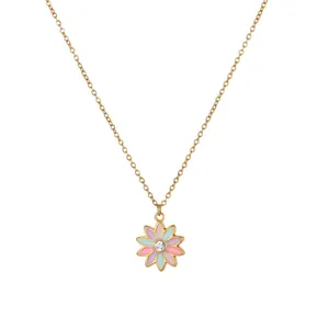 Nahaufnahme einer goldenen Edelstahlkette mit einem bunten Blumenanhänger in Pastell
