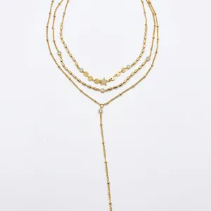 Detail showing multi-layered gold necklace with sparkling star pendant and discs