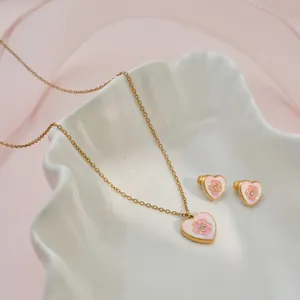Detailopname van de hartvormige sieradenset met roze glitter en bloemendetails