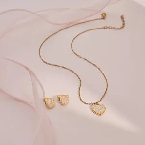 Gedetailleerde weergave van gouden hart sieradenset met kleurrijke glitterafwerking