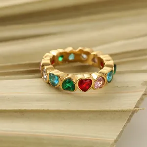 Macro detail of a gold-plated stainless steel ring with multi-colored heart gemstones