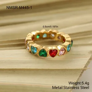 Macro detail of gold stainless steel ring featuring colorful heart gemstones and width