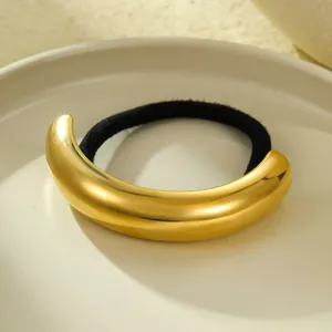 Macro shot of polished 18k gold plated curved stainless steel metallic hair tie accessory