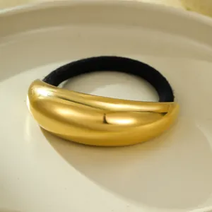 Close-up of a minimalist chunky 18k gold plated curved metal hair tie with black elastic