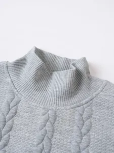 Close-up of a grey men's turtleneck sweater showing high-quality cable knit texture