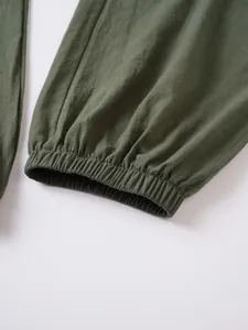 Primer plano del detalle del puño elástico en pantalones casuales de lino y algodón verde.