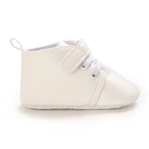 Side view of white faux leather baptism baby shoes with Velcro strap and laces