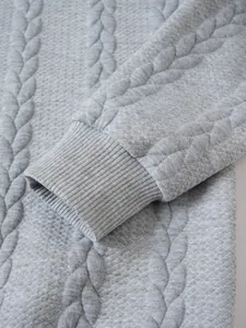 Close-up of the grey jacquard knit sweater showing textured pattern and ribbed cuff